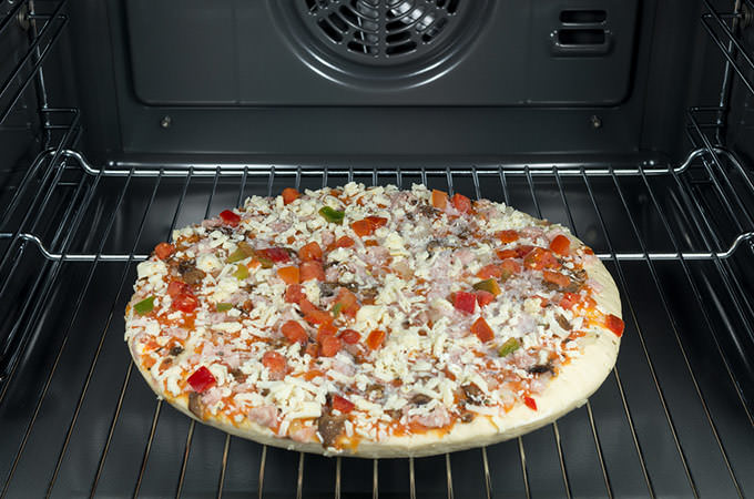 bigstock-Raw-And-Frozen-Pizza-In-The-Ov-54239315