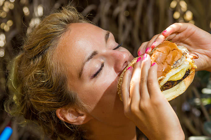 bigstock-Woman-eating-a-cheese-burger-a-96644111