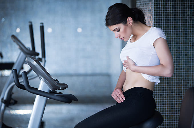 bigstock-Woman-riding-an-exercise-bike--90814313