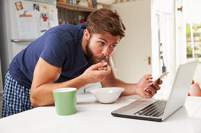 bigstock-Man-Eating-Breakfast-Whilst-Us-86863232